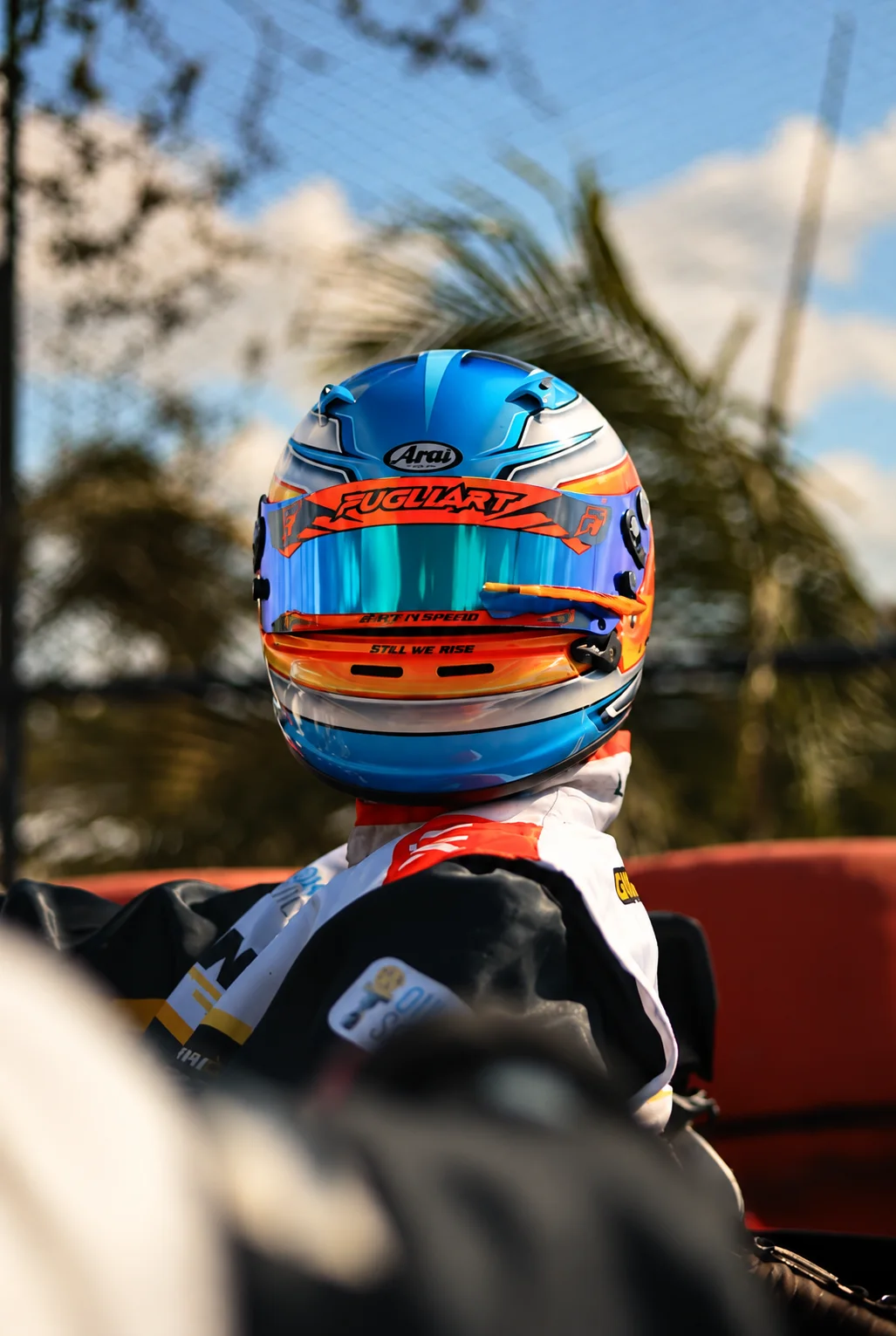 Piloto de kart com capacete azul e laranja